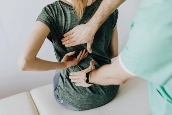 A therapist supporting a patient's back